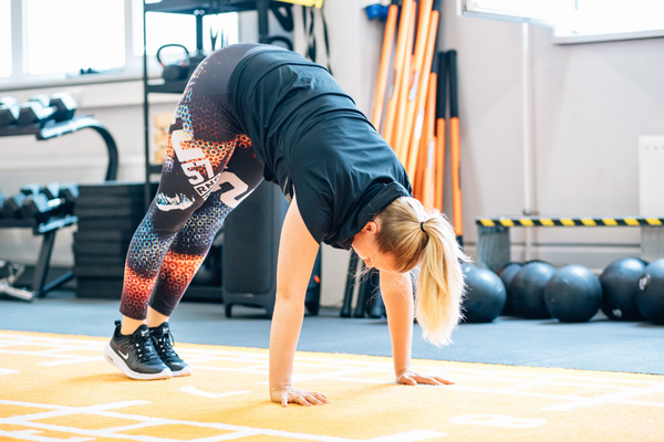 Yoga Einheit im Studio – herabschauender Hund auf der Matte