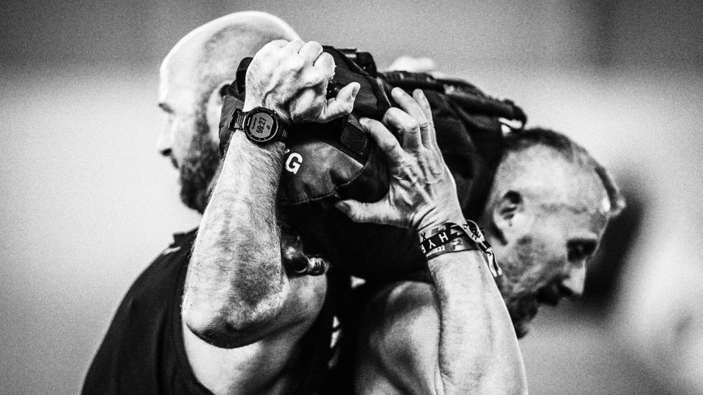 Athlet trainiert mit einem Sandbag im Mein CLUB Burghausen und zeigt volle Körperspannung.