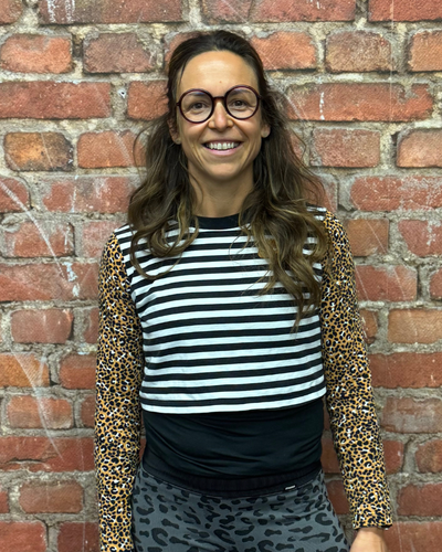 Dani, Calisthenics und Hyrox Trainerin, lacht motiviert im Training.